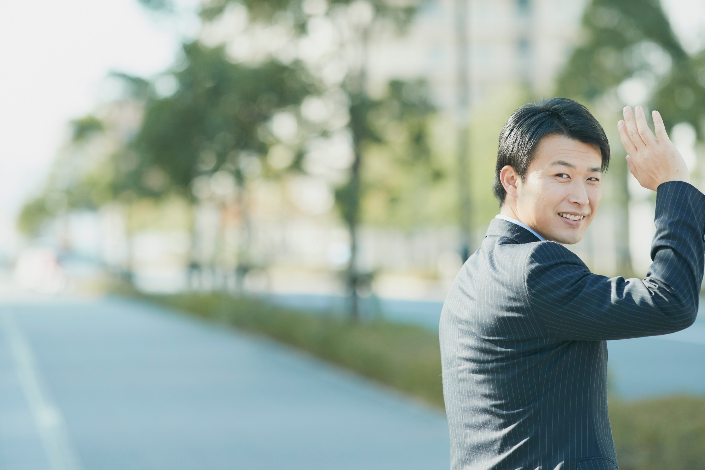 Smiling Japanese Businessman Waving Goodbye